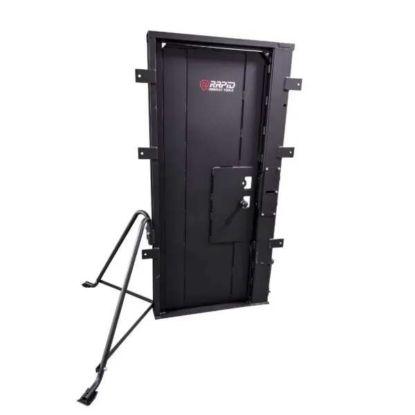 The ALL-IN-ONE BREACHING TRAINING DOOR GEN1 on a metal support frame, designed for forced entry exercises, with a visible brand logo.